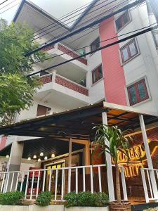 edificio rosa e bianco con balcone di CHORLADA LANNA HOTEL a Chiang Mai
