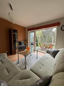 un soggiorno con un divano e un tavolo di Poilsis Urbo Nidoje a Nida