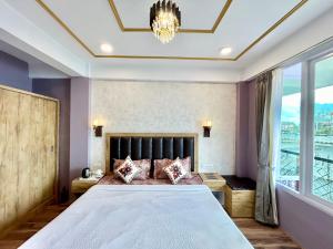 a bedroom with a large bed and a chandelier at Yepplo's Stunning Mountain View 2-bedroom apartment with Private Kitchen - 24hrs Caretakers & Power Backup in Darjeeling