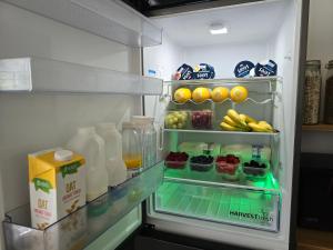 an open refrigerator filled with milk and fruit and juice at Victorian Renovation Room 3 in Liverpool