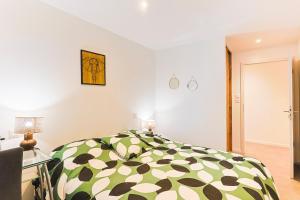 a bedroom with a bed with a green and white comforter at Mas Lac Blanc - Terrasse - Sauna - Parking in Orbey +51 photos