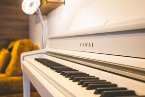 a white piano with the words kawi on it at Mas Lac Blanc - Terrasse - Sauna - Parking in Orbey