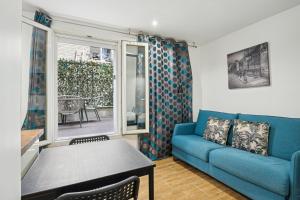 a living room with a blue couch and a table at Tour Eiffel Apartment in Paris