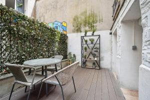 a patio with a table and chairs and a fence at Tour Eiffel Apartment in Paris