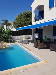 a swimming pool in front of a house at Villa Maya in Paralimni