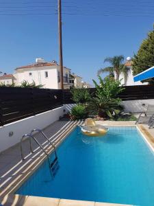 a large blue swimming pool with a slide at Villa Maya in Paralimni