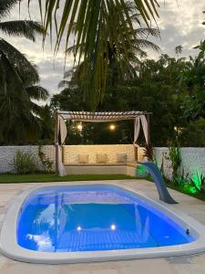 Una gran piscina azul en un patio trasero con un sofá. en Casa Praiana Moitas, en Praia de Moitas