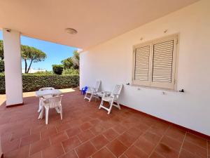 a patio with chairs and a table and a window at L'isola di Gianni by Ortigia Apartments in Plemmirio