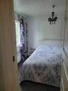 a bedroom with a bed and a window and a chandelier at Rantatalo in Pori