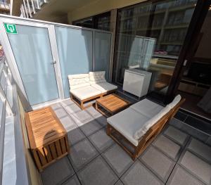 un balcon avec un canapé et des tables sur un immeuble dans l'établissement La Casa de la Playa, à Middelkerke 14 autres photos
