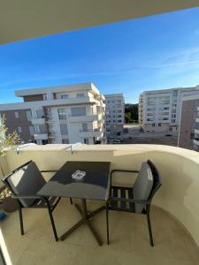 una mesa y sillas en un balcón con edificios en Apollo 2, en Ulcinj