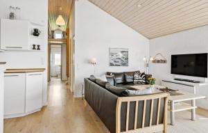 a living room with a couch and a table at Holiday Home Vejlby Klit in Harboør
