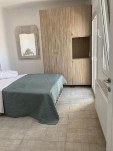 a bedroom with a bed with a green blanket on it at Panormos Village,Mykonos in Mýkonos City