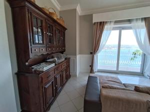 eine Küche mit einem Sofa und einem großen Fenster in der Unterkunft Relais Tiaré Bed and Breakfast in Bacoli