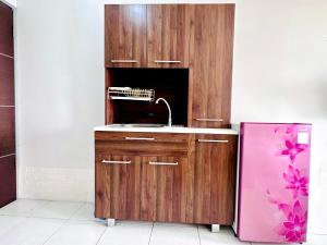 a kitchen with a sink and a purple refrigerator at Pleasant Tamansari Prospero Studio Apartment in Sidoarjo by Le Ciel Hospitality in Sidoarjo