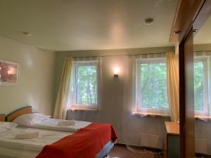 a bedroom with two beds and two windows at Hotel Promenade in Palanga
