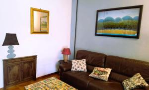 a living room with a brown couch and a painting at Il Piano di Mezzo in Manziana
