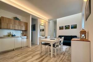 a kitchen and a living room with a table and chairs at Almar esclusivo e centrale in Camogli