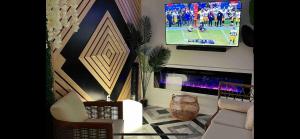 un soggiorno con TV e divano bianco di Cozy 4bedroom Cottage with hotub/suana a Dundalk