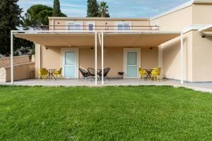a house with a patio with chairs and a lawn at MILLE SUITE GARDEN in Noto