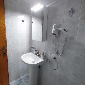 a bathroom with a white sink and a mirror at Voukamvilia apartment in Paralia Kimis +34 photos