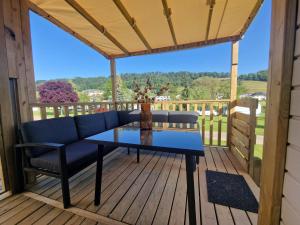 a patio with a blue table and chairs on a deck at Chalet Mullerthal in Reisdorf