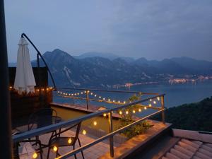 a balcony with lights and a view of the water at Lake Lodge in Fonteno +7 photos