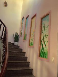 a staircase in a home with paintings on the walls at Hiệp Đạt Motel in Kon Tum