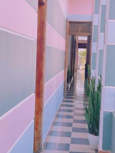 a hallway with pink and blue walls and a checkered floor at Hiệp Đạt Motel in Kon Tum