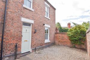 a brick house with a white door at Central Stays - Luxury Central Townhouse - With Free Parking in Chester