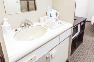 a bathroom with a white sink and a mirror at HOTEL MYSTAYS Nippori in Tokyo