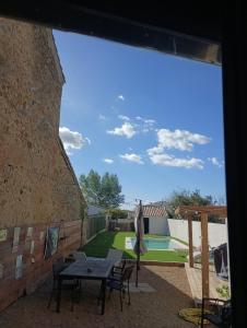 a patio with a table and chairs and a pool at chambre a bizanet in Bizanet