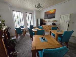 a dining room with wooden tables and blue chairs at Victorian Renovation Room 4 in Liverpool