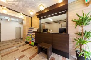 a waiting area of a library with a desk and a mirror at HOTEL MYSTAYS Nippori in Tokyo