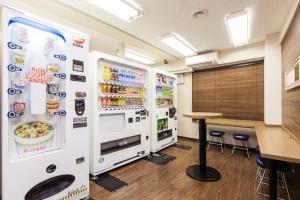 um escritório com um grande frigorífico e uma mesa em HOTEL MYSTAYS Nippori em Tóquio