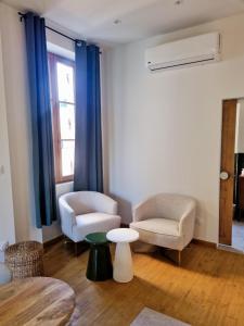 a living room with two chairs and a table at Casita Suite Hyper centre Sarlat in Sarlat-la-Canéda