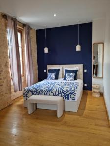a bedroom with a bed with blue walls and wooden floors at Casita Suite Hyper centre Sarlat in Sarlat-la-Canéda