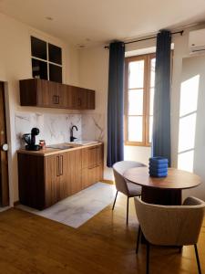 a kitchen with a table and a sink and a table and chairs at Casita Suite Hyper centre Sarlat in Sarlat-la-Canéda