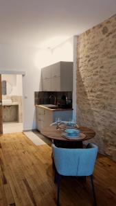 a kitchen with a wooden table and blue chairs at Casita Suite Hyper centre Sarlat in Sarlat-la-Canéda +21 photos