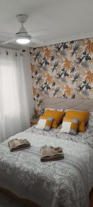 a bedroom with a large bed with yellow and white pillows at Apartamento Isabel in Torrevieja