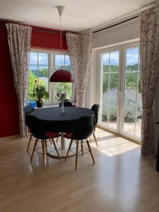 a dining room with a table and chairs and windows at Ferienwohnung Nauborn in Wetzlar mit großer Terrassse, ruhig gelegen in Wetzlar