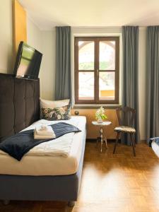 a bedroom with a bed with a television on top of it at Villa Fantasia Budget Boutique Hotel in Füssen