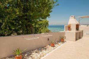 un muro de retención con plantas y un edificio en Sea Oasis Residence, en Limenas 25 fotos más