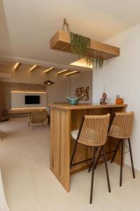 a kitchen with two chairs and a counter in a room at Ionian Blue Luxury Apartment in Marathopolis