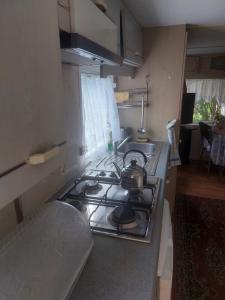 a kitchen with a stove with a tea pot on it at Olga in Łeba