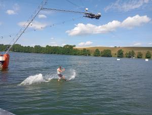 a man water skiing in a lake with a crane at Pokoje PRZY SZELMENCIE in Jeleniewo