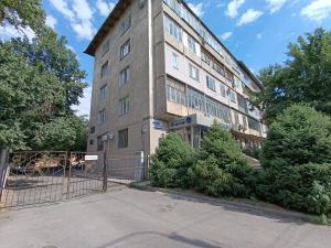 een hoog gebouw met een hek ervoor bij AURA on Tynystanova street 199 in Bisjkek