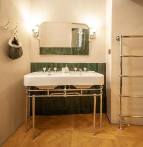 ein Badezimmer mit Waschbecken und Spiegel in der Unterkunft Domus Dionisio Apt by Addler House Ospitality in Syrakus