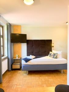 a bedroom with a large bed with a large headboard at Villa Fantasia Budget Boutique Hotel in Füssen