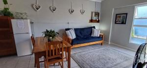 a living room with a table and a blue couch at Winemaker's Rest in Oudtshoorn